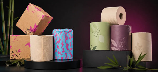 Skid Slayer unbleached bamboo toilet paper with bold kraft and cyan-pink packaging compared against Betterway natural bamboo toilet paper in muted green and burgundy packaging.