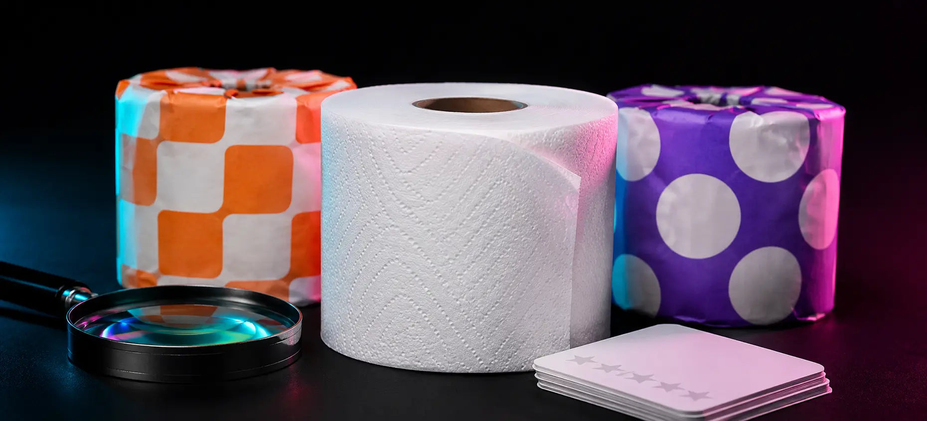 White toilet paper roll displayed with colorful wrapped rolls, a magnifying glass, and review cards on a dark studio background.
